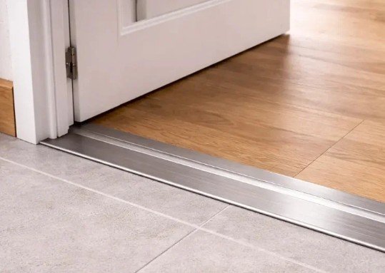 Aluminium threshold fitted under an interior door